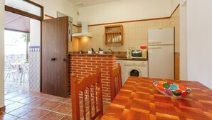 Una cocina compacta con comedor, lavadora y microondas.