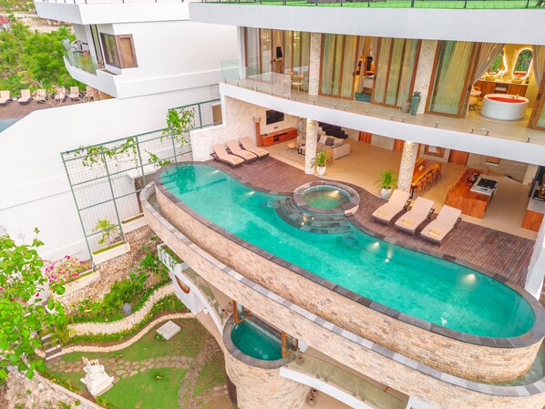 Un hôtel moderne doté d’une grande piscine extérieure à débordement, d’une terrasse sur le toit et d’un jardin bien entretenu.