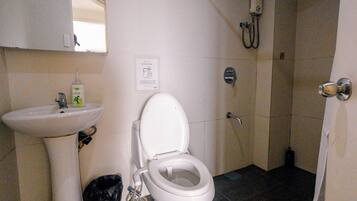 A bathroom with a toilet, sink, and shower.