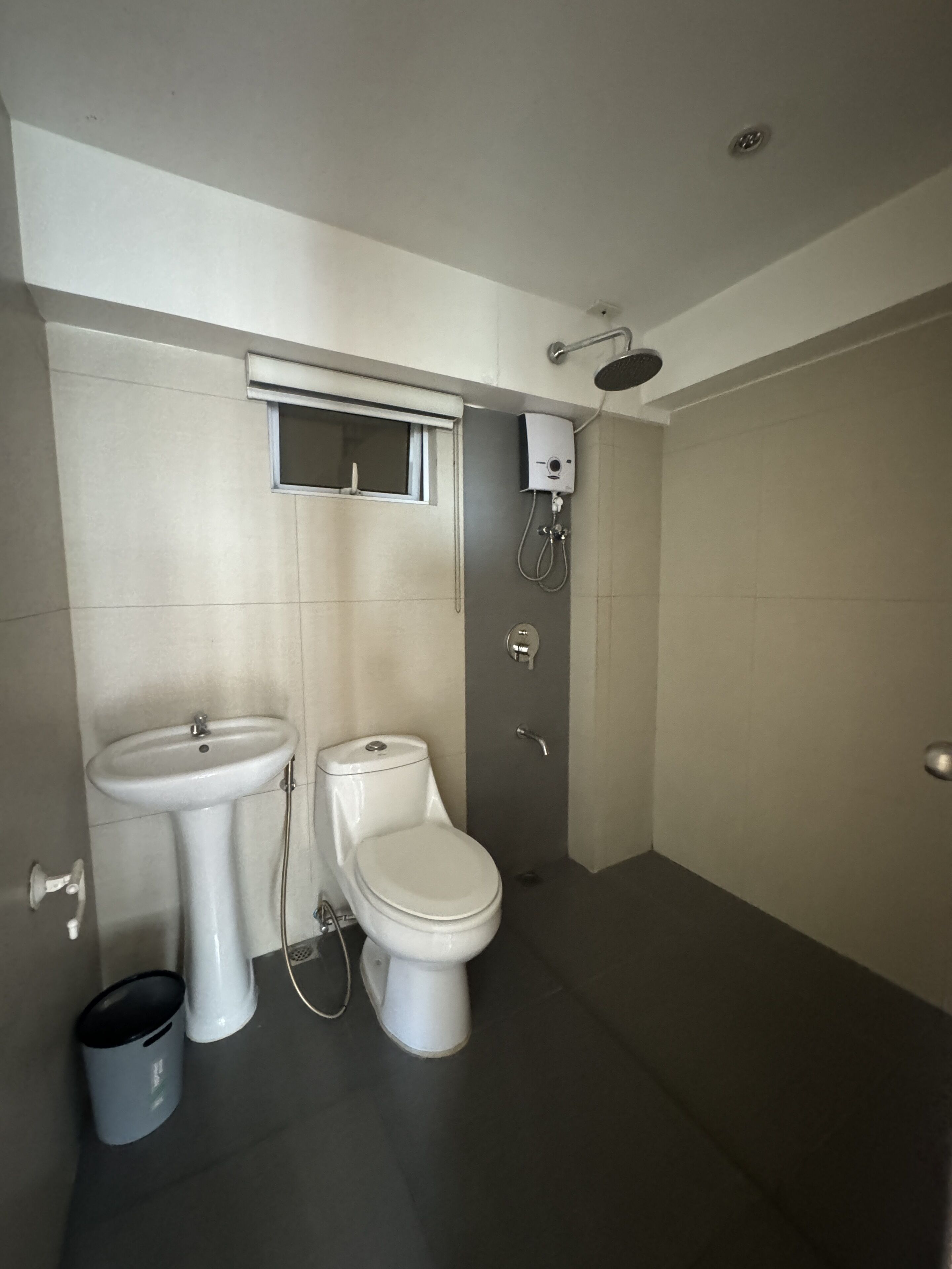 Een moderne badkamer met een wastafel op voetstuk, toilet en douchecabine.