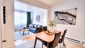 A modern living room with a dining area, featuring a sofa set, a coffee table, and a dining table with chairs.