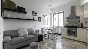 A modern kitchen with a gas stove, oven, and a dining area with a table and chairs.