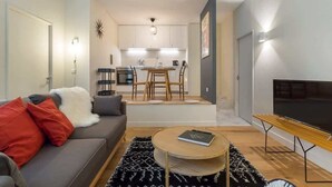 Een moderne woonkamer met een bank, salontafel en een flatscreen televisie.
