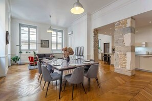 Ein geräumiger Essbereich mit einem langen Tisch, modernen Stühlen und Pendelleuchten.