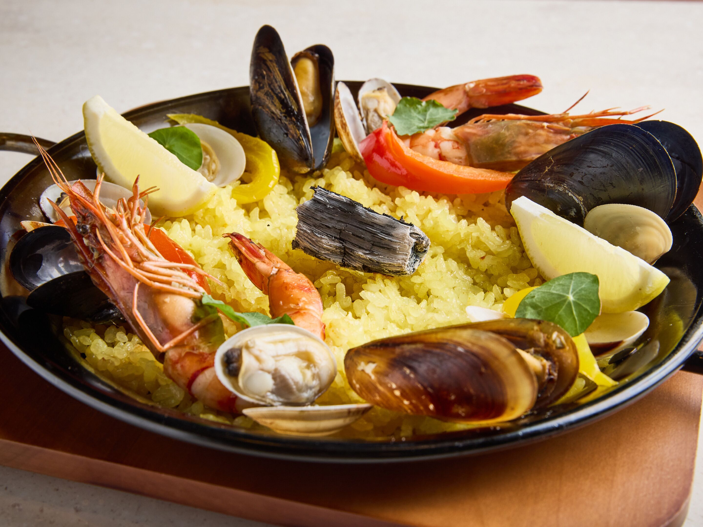 Plato de mariscos con arroz, camarones, mejillones y rodajas de limón.