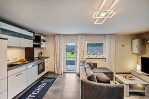Une cuisine moderne avec un coin repas, un canapé et un téléviseur.