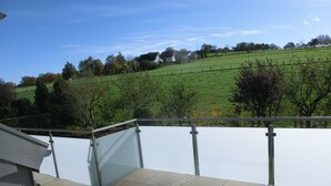 A balcony with a view of a green field and trees. - Apartment 'Wiesenblick' with Balcony and Wi-Fi (Brilon)
