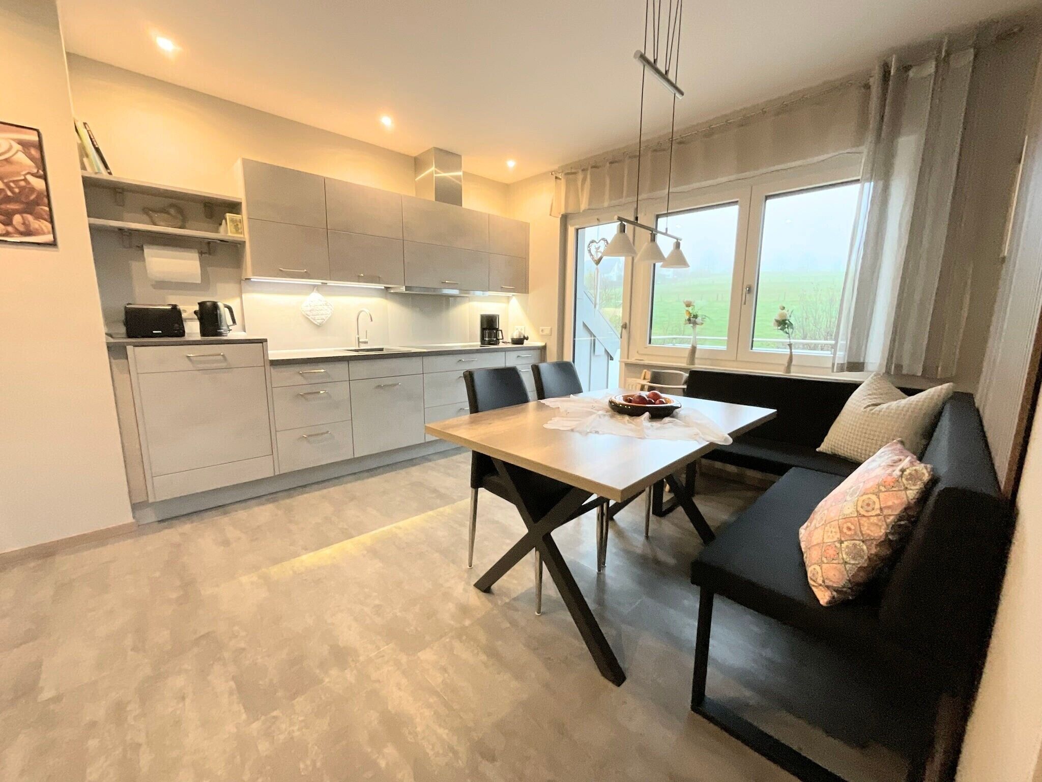 Una cocina moderna con comedor, sofá y vistas al exterior.