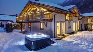 A chalet with a wooden balcony, a hot tub, and a snow-covered landscape. - Chalet 200m2 | Fireplace | Jacuzzi | Sauna | Views (Chamonix-Mont-Blanc)