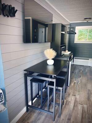 A modern kitchen with a black countertop, stainless steel appliances, and a window providing natural light. - TeePee Room 10-Newly Renovated (Roscommon)