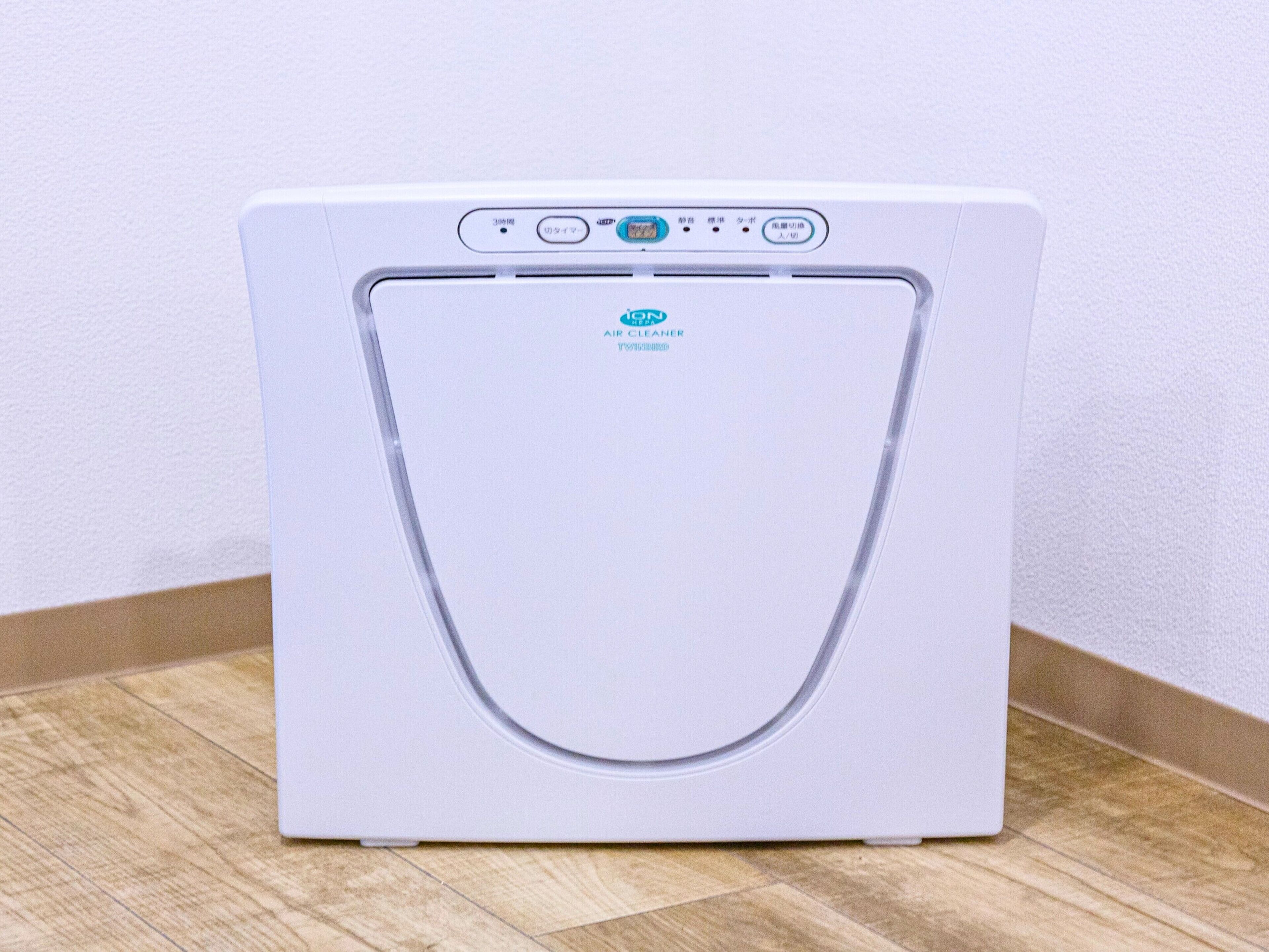 Purificador de aire blanco con panel de control y una abertura circular en la parte frontal.