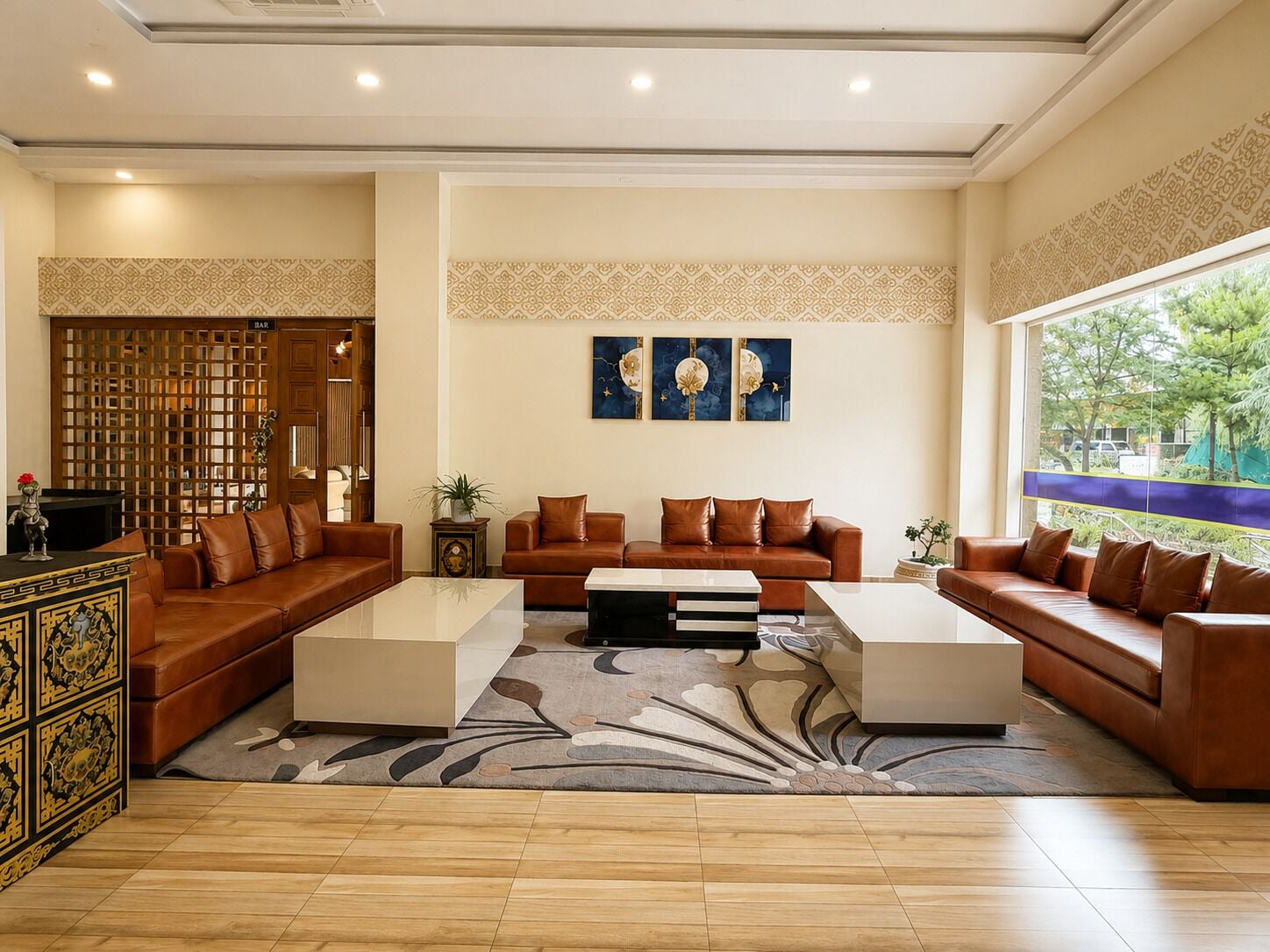 A spacious living room with a large sofa set, a coffee table, and a decorative screen.