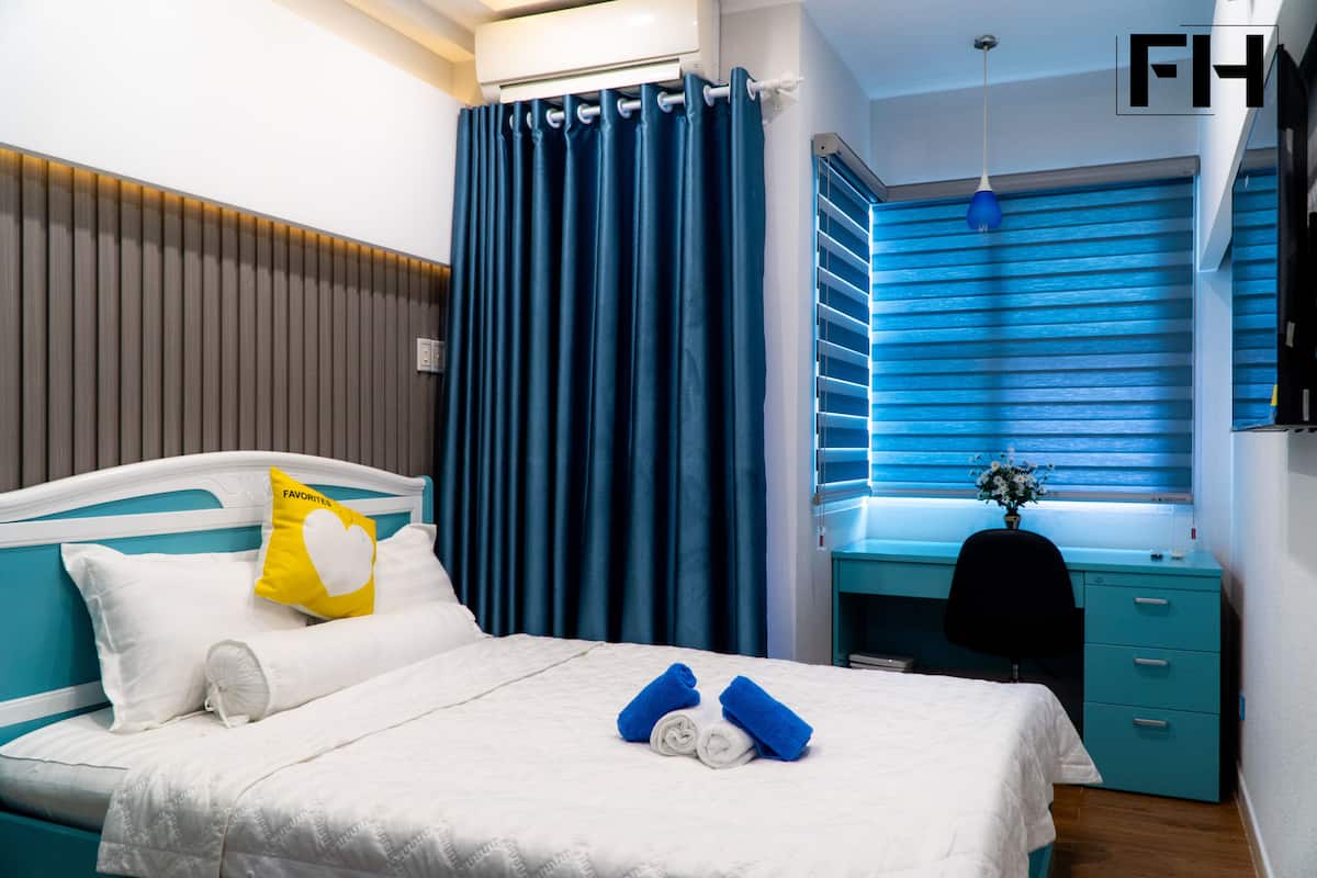 Une chambre d’hôtel avec un lit, un bureau et une fenêtre équipée de stores.