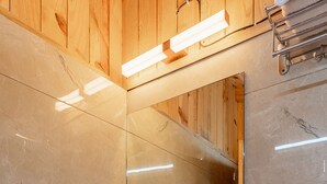 Ein Badezimmer mit Waschbecken, Holdekor-Schränken, einem Spiegel und einem Handtuchhalter.