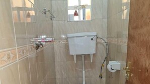 A small, tiled bathroom with a toilet, a bidet, and a trash can. - Lux Suites Geanna Suites Nanyuki (Nanyuki)
