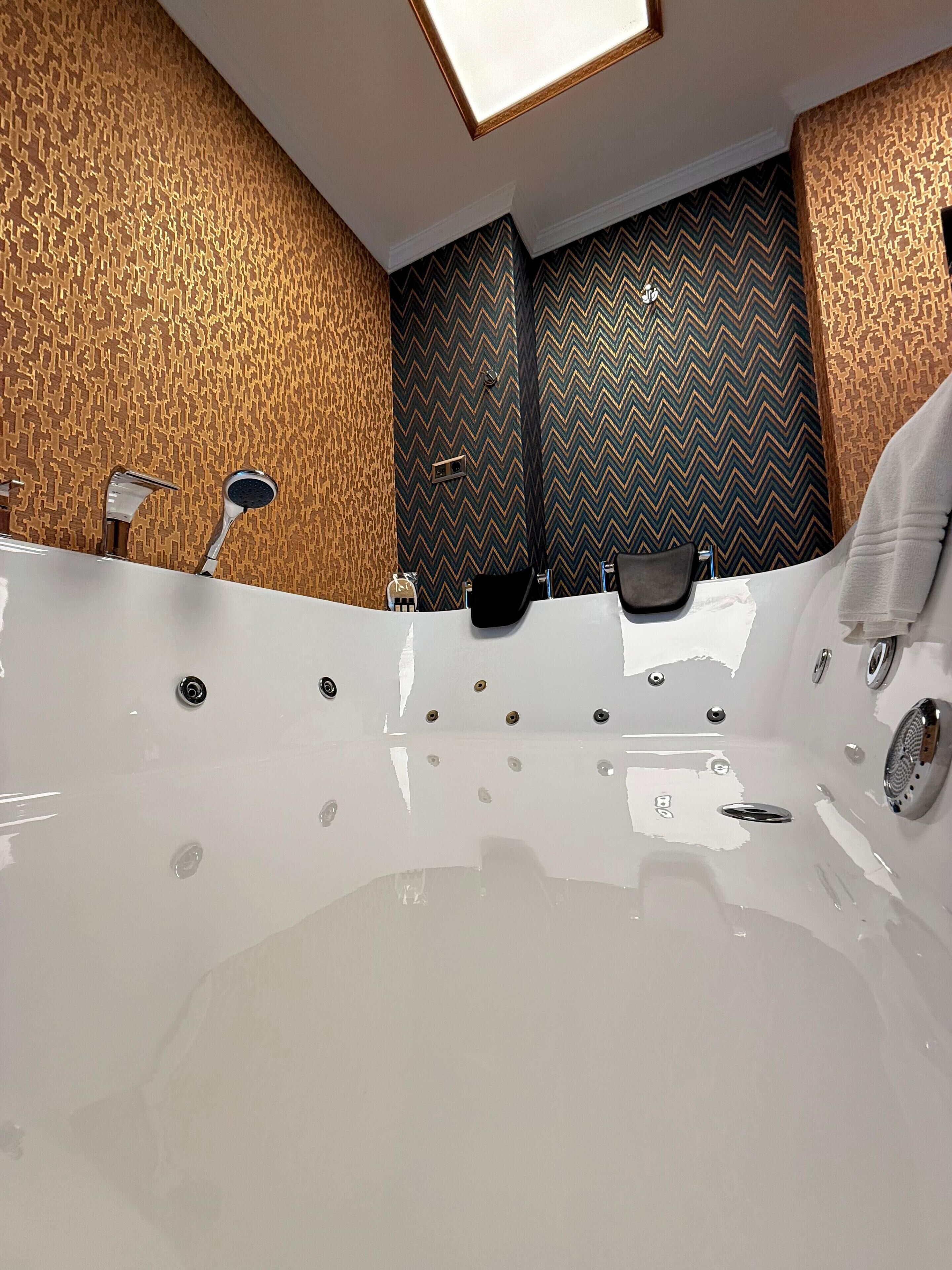 Une salle de bain moderne avec une grande baignoire, une douche et un meuble-lavabo.
