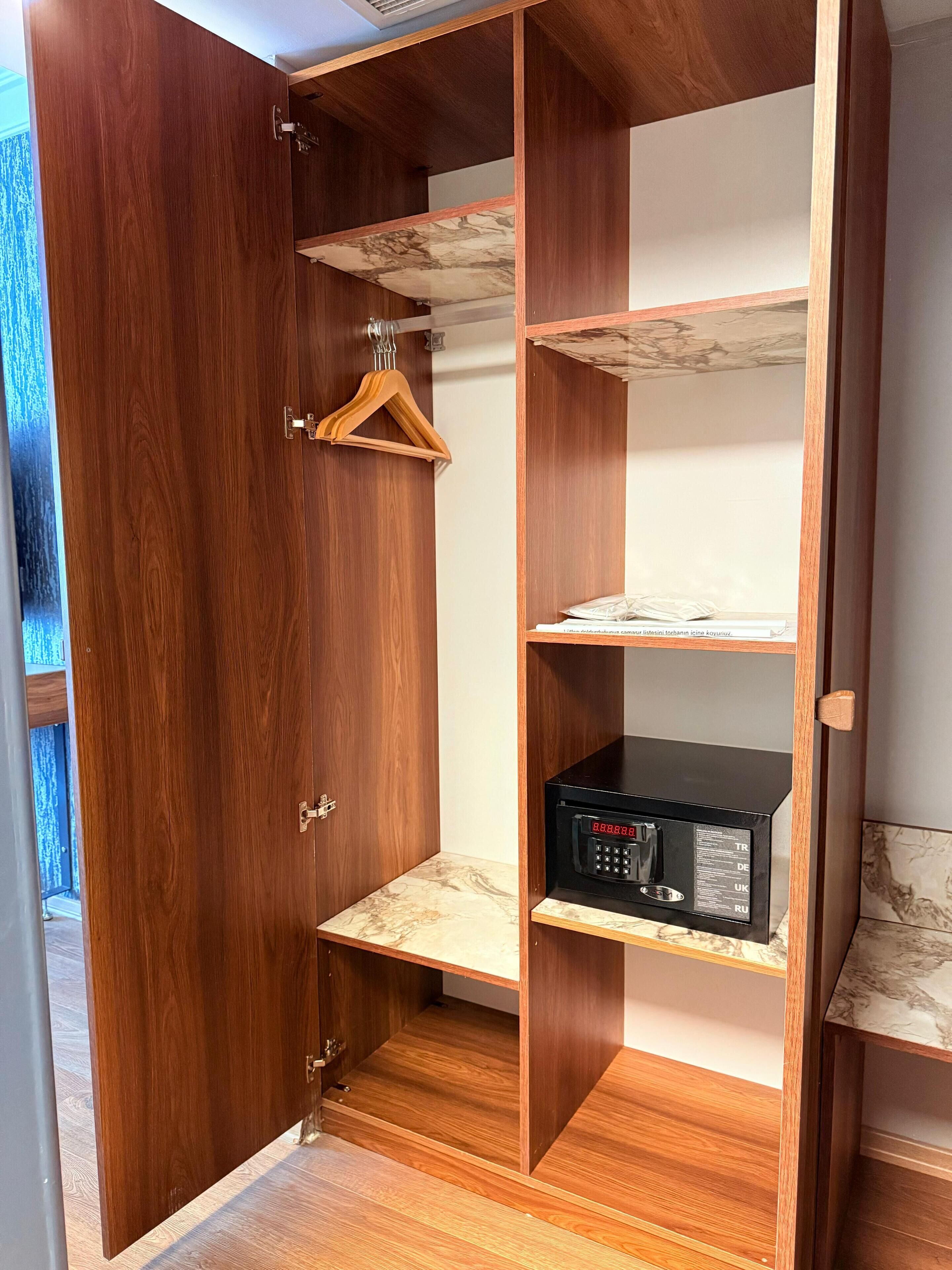 Een houten garderobe met een magnetron op het onderste plank.