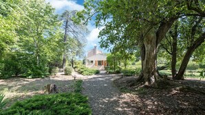 A house surrounded by a garden with a gravel path leading to it.
