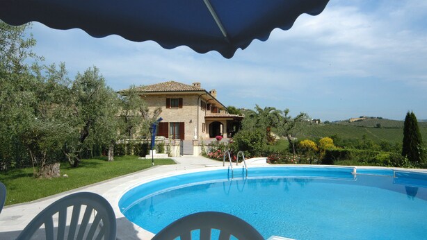 A swimming pool with a house in the background.
