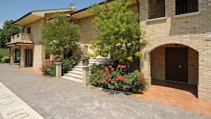 A traditional stone building with a brick facade, a wooden door, and a small balcony.