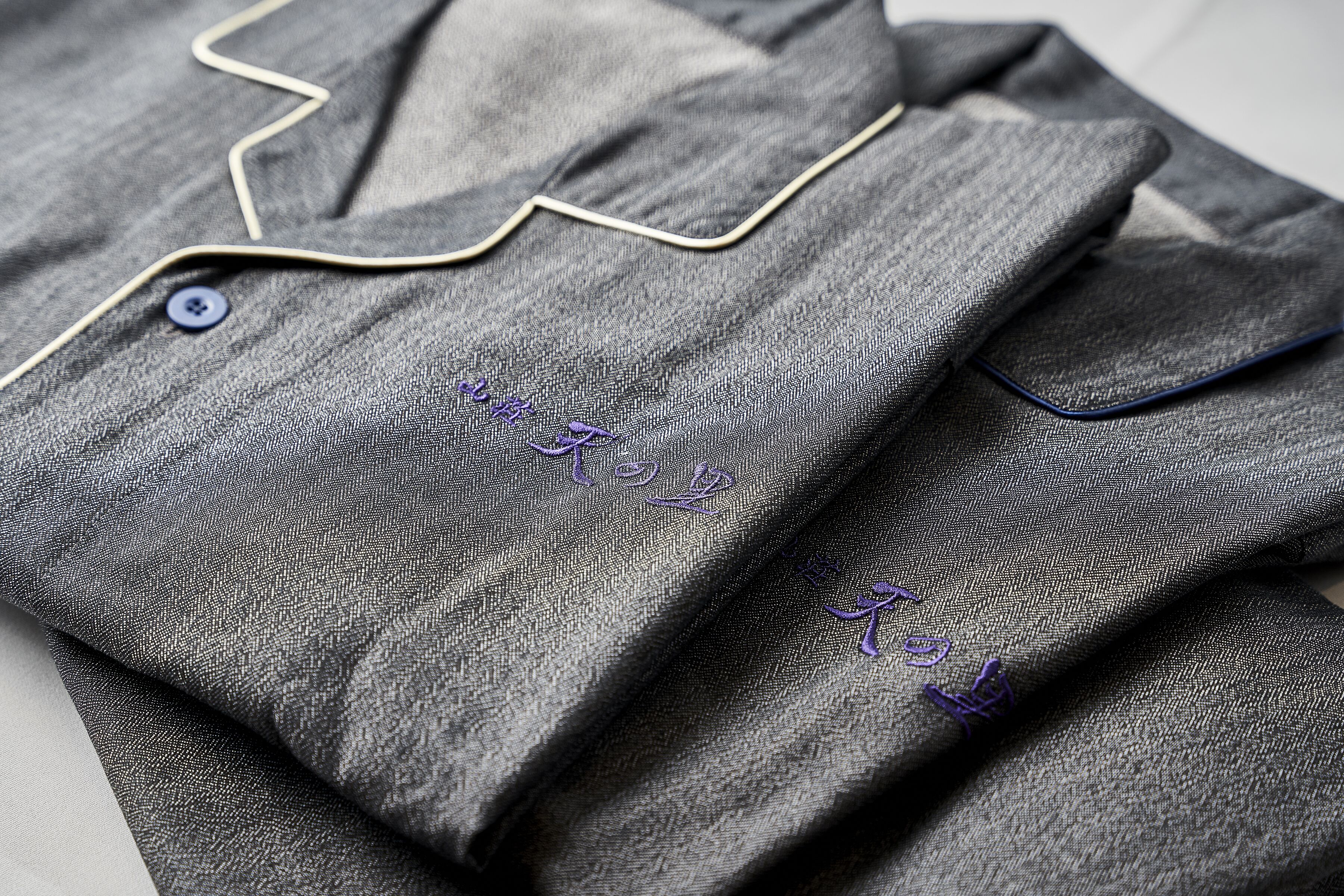 A neatly folded garment with a button and a zipper.