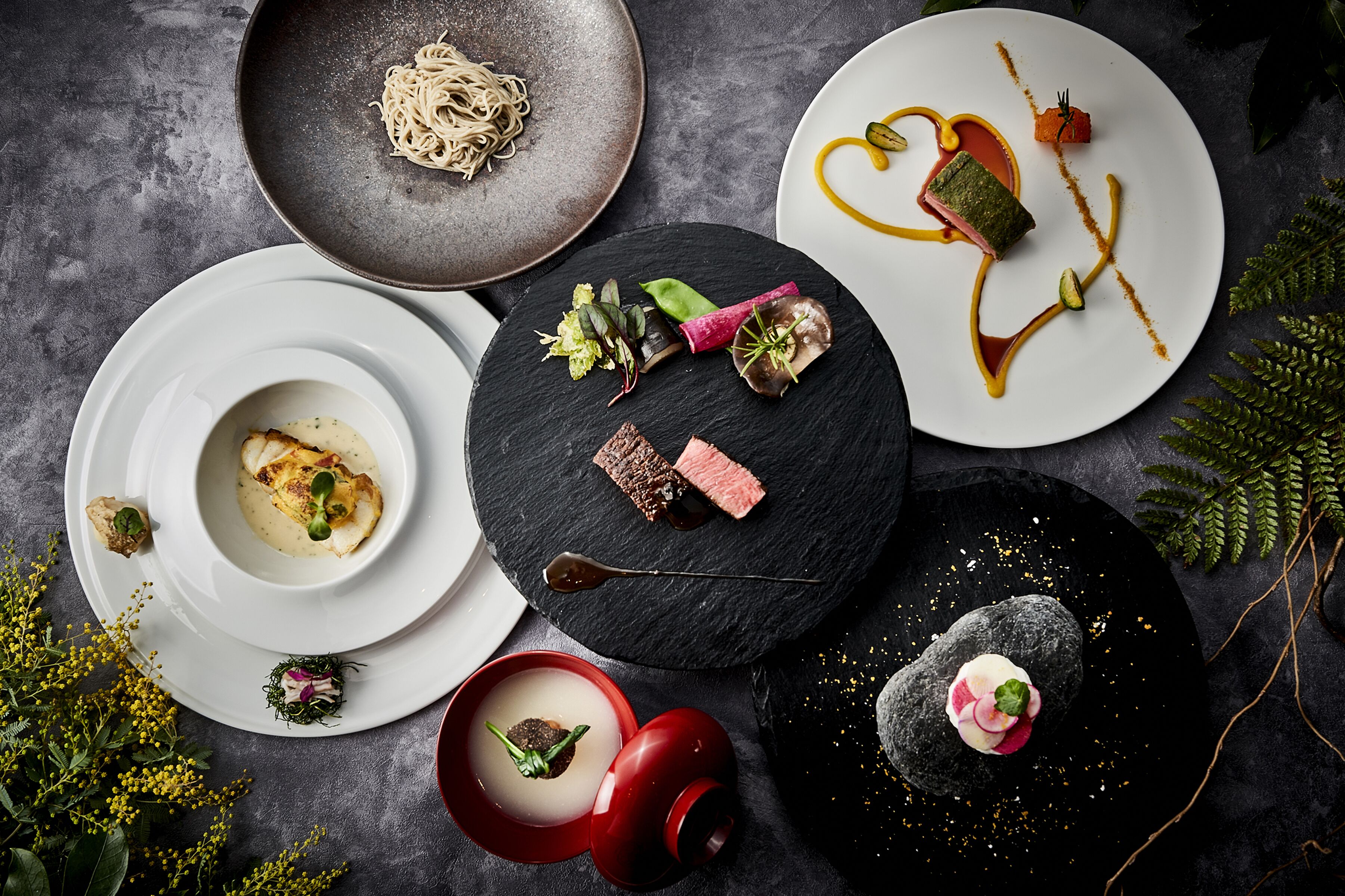 Variedad de platos, incluyendo un tazón de sopa y un plato con una presentación de comida en forma de corazón.