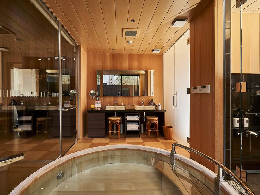 Un baño moderno con ducha de vidrio, paneles de madera y un espejo grande sobre el lavamanos.