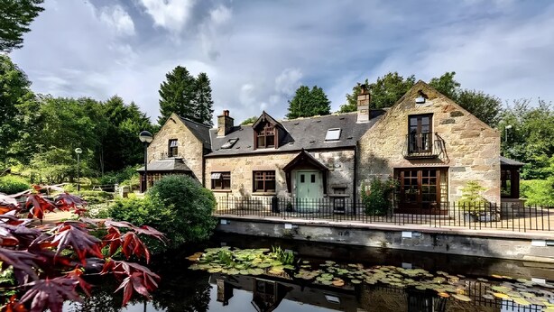 A stone building with a pond in front, surrounded by trees. - Lurg Lodge (Inverurie)