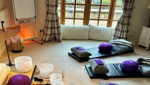 A room with tatami mats, cushions, and a tea ceremony setup including bowls and a tea kettle. - Lurg Lodge (Inverurie)