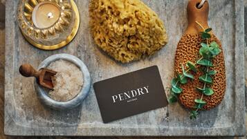 A tray with a candle, a sponge, a wooden scoop, and a card labeled "PENDRY NATIRAR".