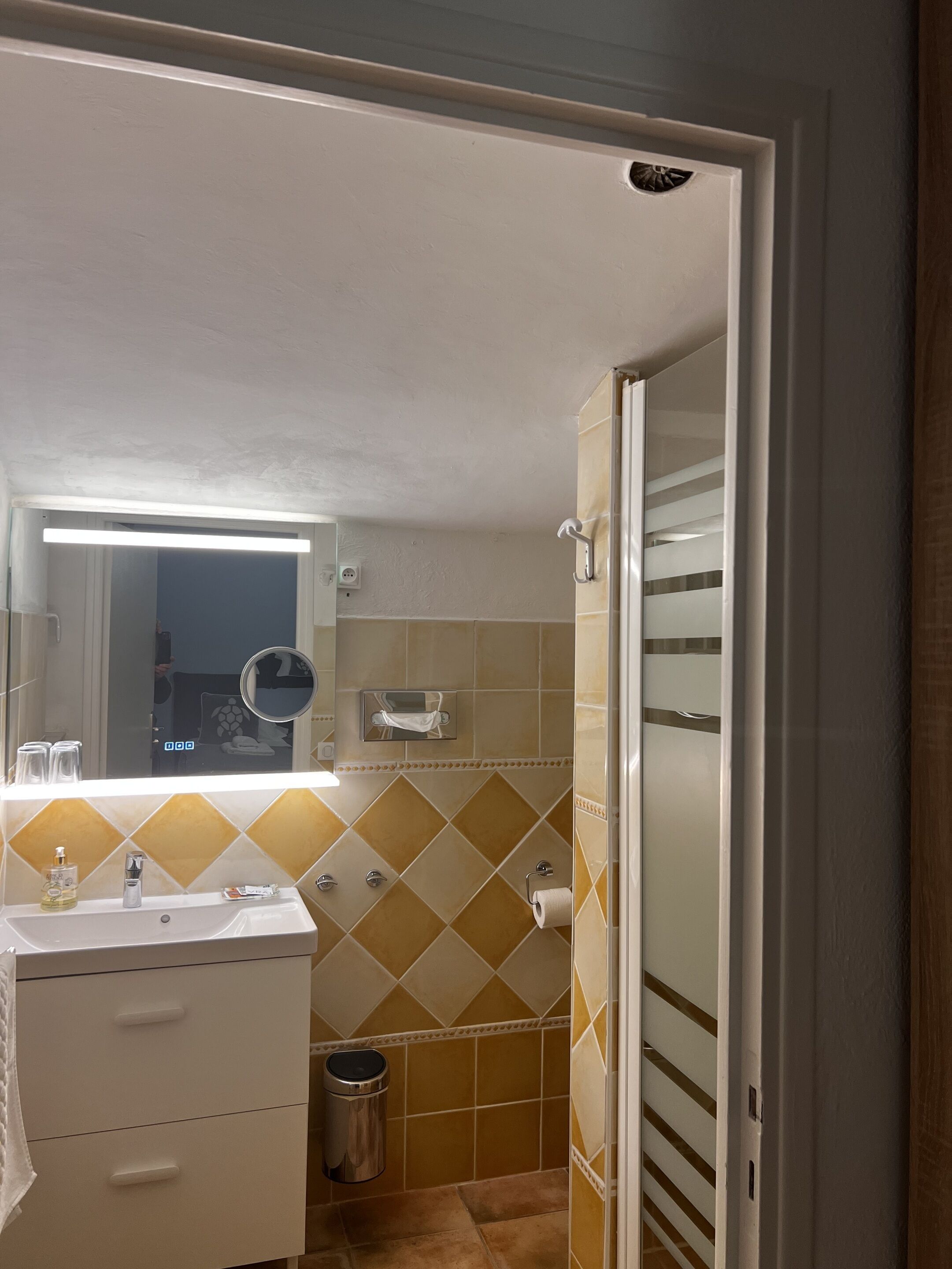 Un baño con lavamanos, espejo e inodoro.