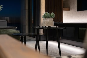 A modern outdoor seating area with a table and chairs, a potted plant, and a view of the cityscape. - Aurum 501 (Cape Town)