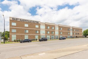 Un immeuble à plusieurs étages portant l’enseigne « East Nashville Suites », ce qui indique qu’il s’agit d’un hôtel.
