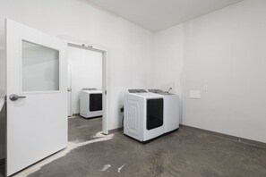 A laundry room with two washing machines and a door leading to another room. - Condo Near Downtown - WALK to restaurants, bars & music (Nashville)