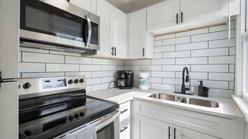 Coffee/tea maker, fridge, stovetop, cookware/dishes/utensils