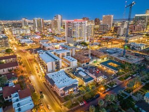 An aerial view of a cityscape at dusk with high-rise buildings, roads, and a construction crane. - Modern Apartment in the Heart of Phoenix (10) (Phoenix)