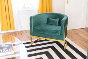 A teal armchair with a gold frame, positioned on a black and white striped rug. - Historic Roosevelt Row Apt Near Dining & (Phoenix)