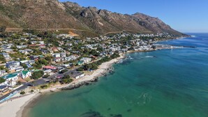 Une ville côtière avec une plage, des maisons et des montagnes.