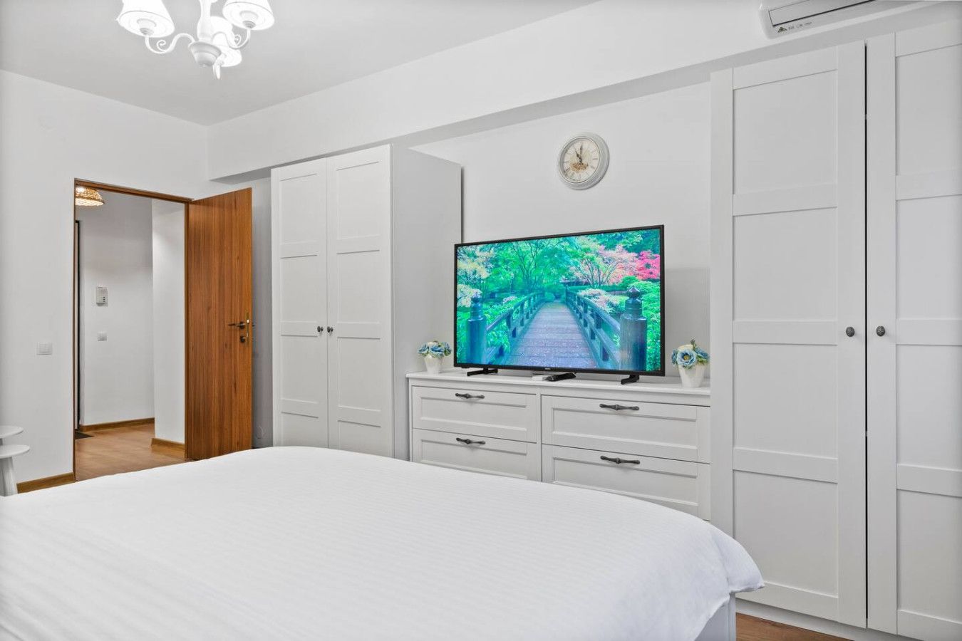 Ein Schlafzimmer mit einem Bett, einem Fernseher auf einer Kommode und einem Kleiderschrank.