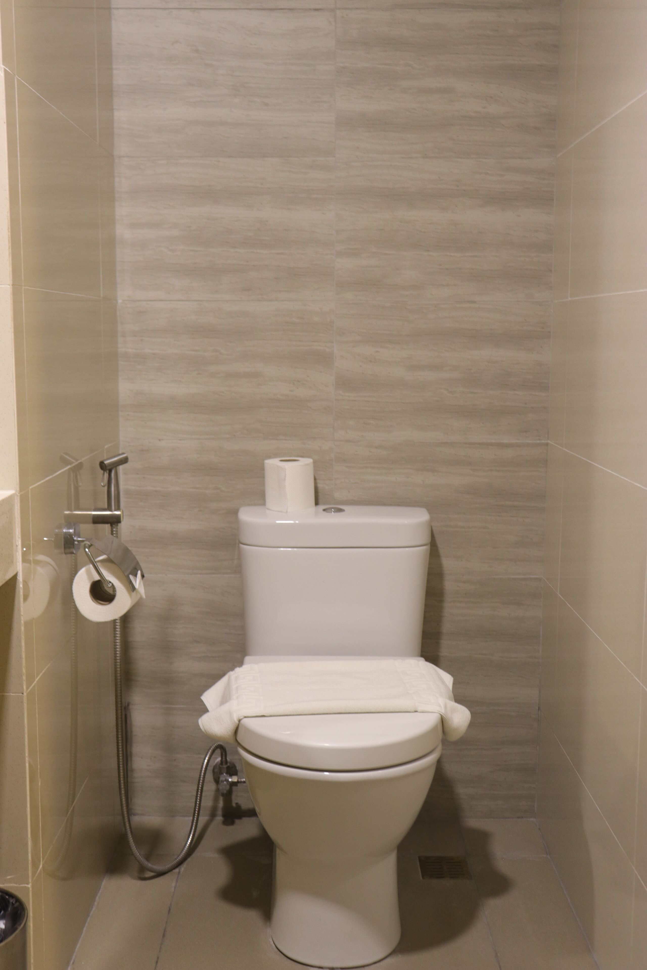 Un baño moderno con inodoro, ducha y toallero.