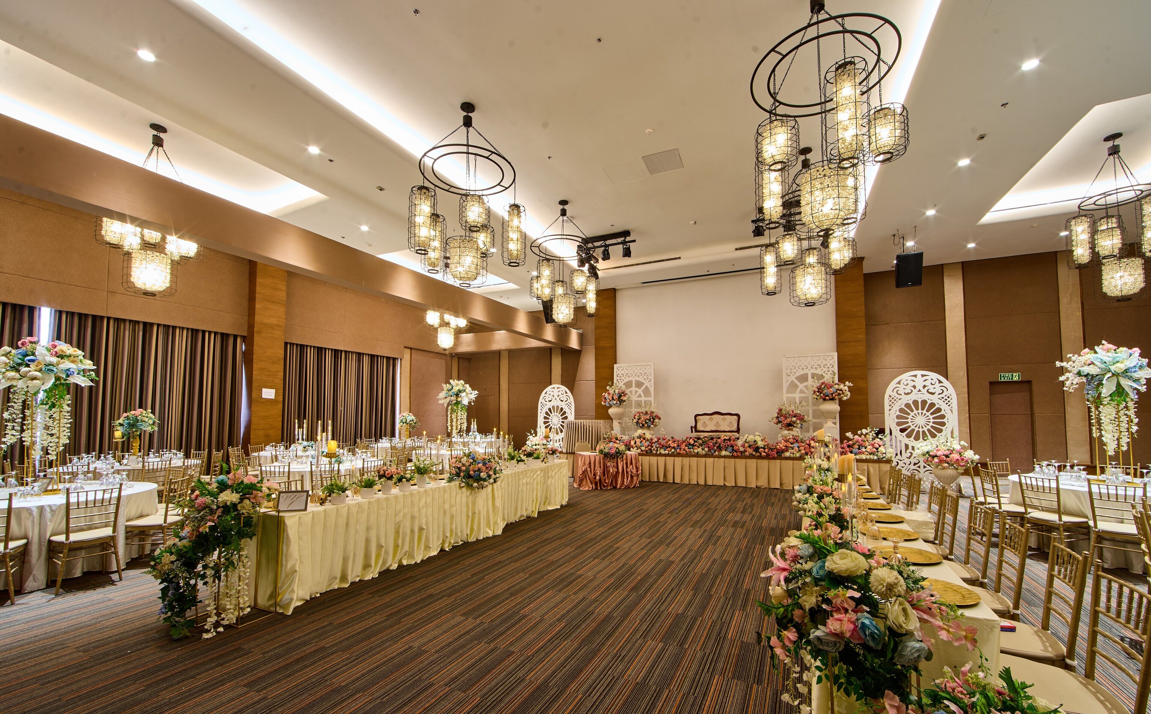 Un salón de banquetes con mesas largas, candelabros y adornos florales.
