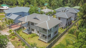 A modern residential complex with multiple two-story houses, each featuring a flat roof and a balcony. - Palm Holiday Apartments (Praslin Island)