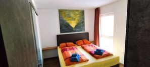 Cozy retreat with a single bed, painting, and window with curtains.