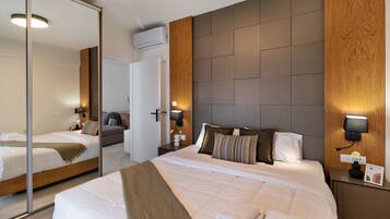 Een hotelkamer met een groot bed, een spiegel, een houten hoofdbord en een nachtkastje met een lamp.