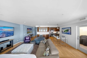 A modern living room with a sofa, ottoman, and a television. - La Jolla Ocean Front Escape (San Diego)