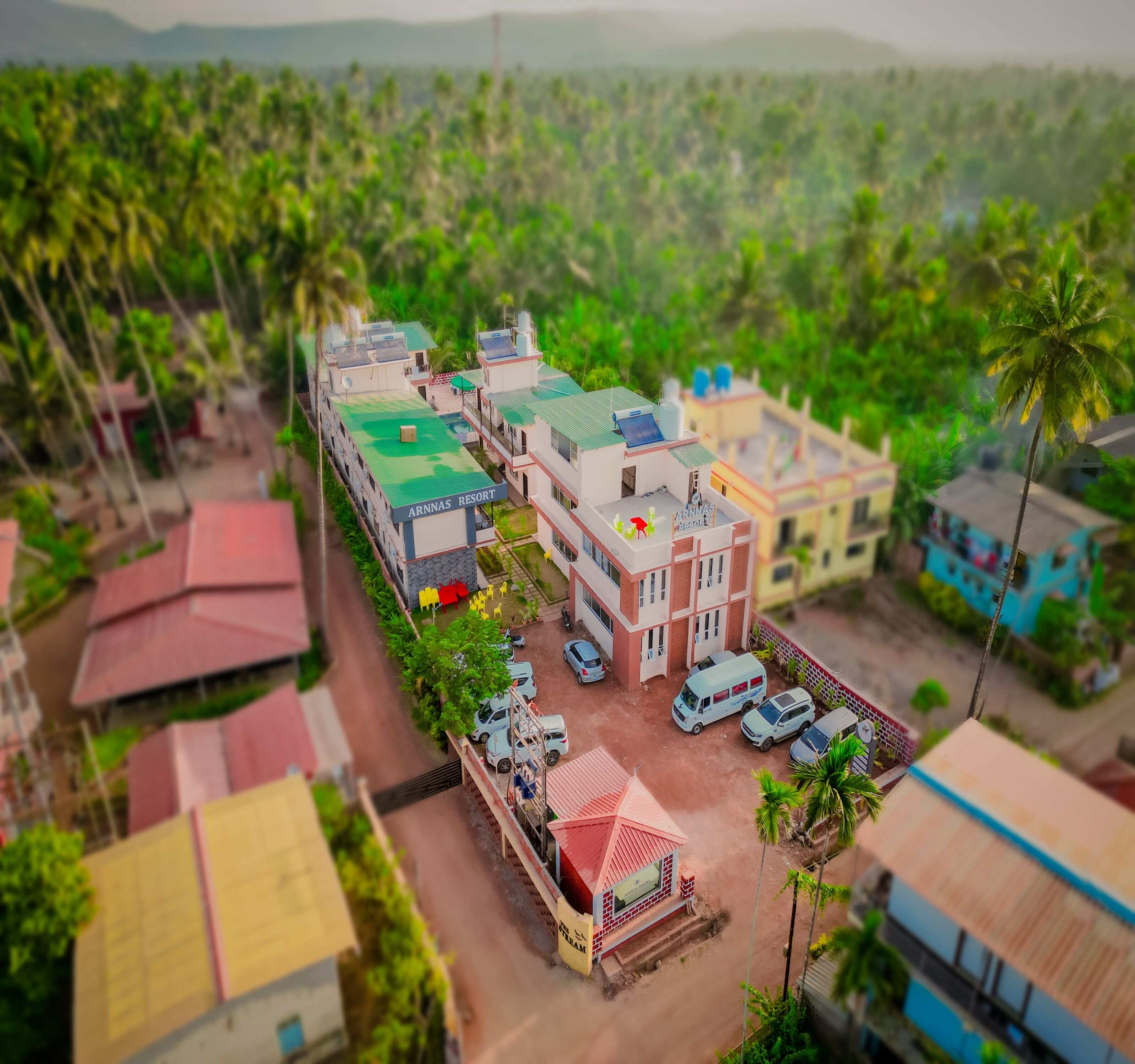 A model of a resort with multiple buildings, a parking area, and surrounding greenery.