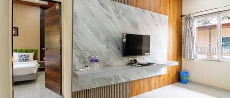 A modern hotel room with a marble wall, a mounted TV, and a wooden accent wall.