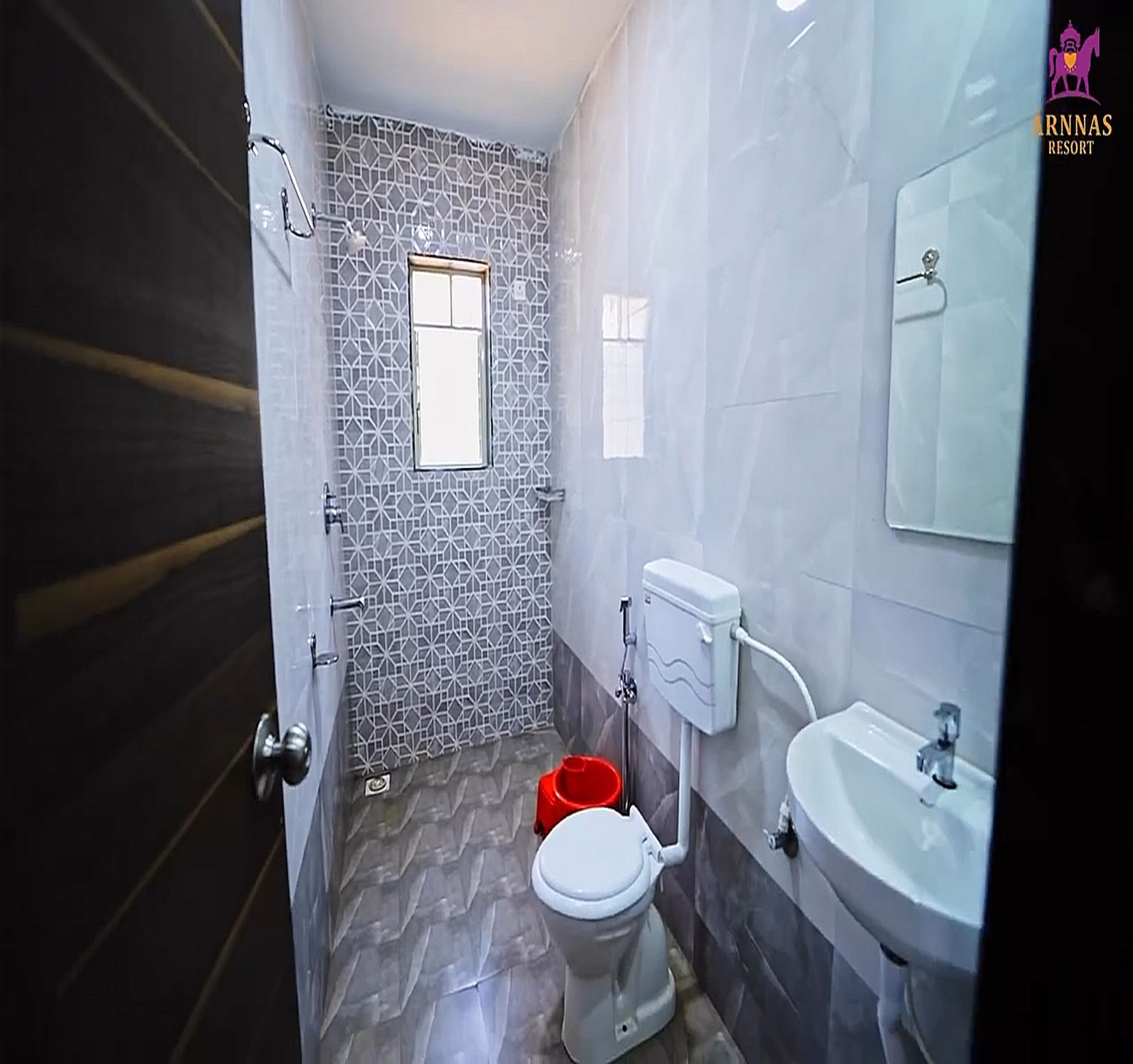 A bathroom with a toilet, sink, and a small window.
