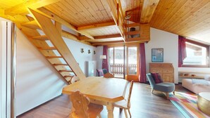 Un intérieur en bois comprenant une table à manger, des chaises, un canapé et un escalier.