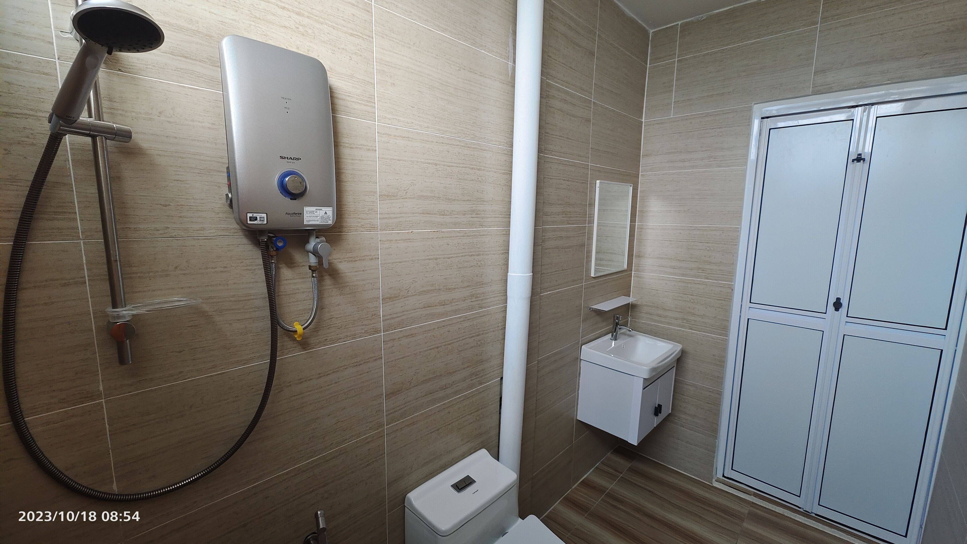 A bathroom with a shower, toilet, and storage cabinet.